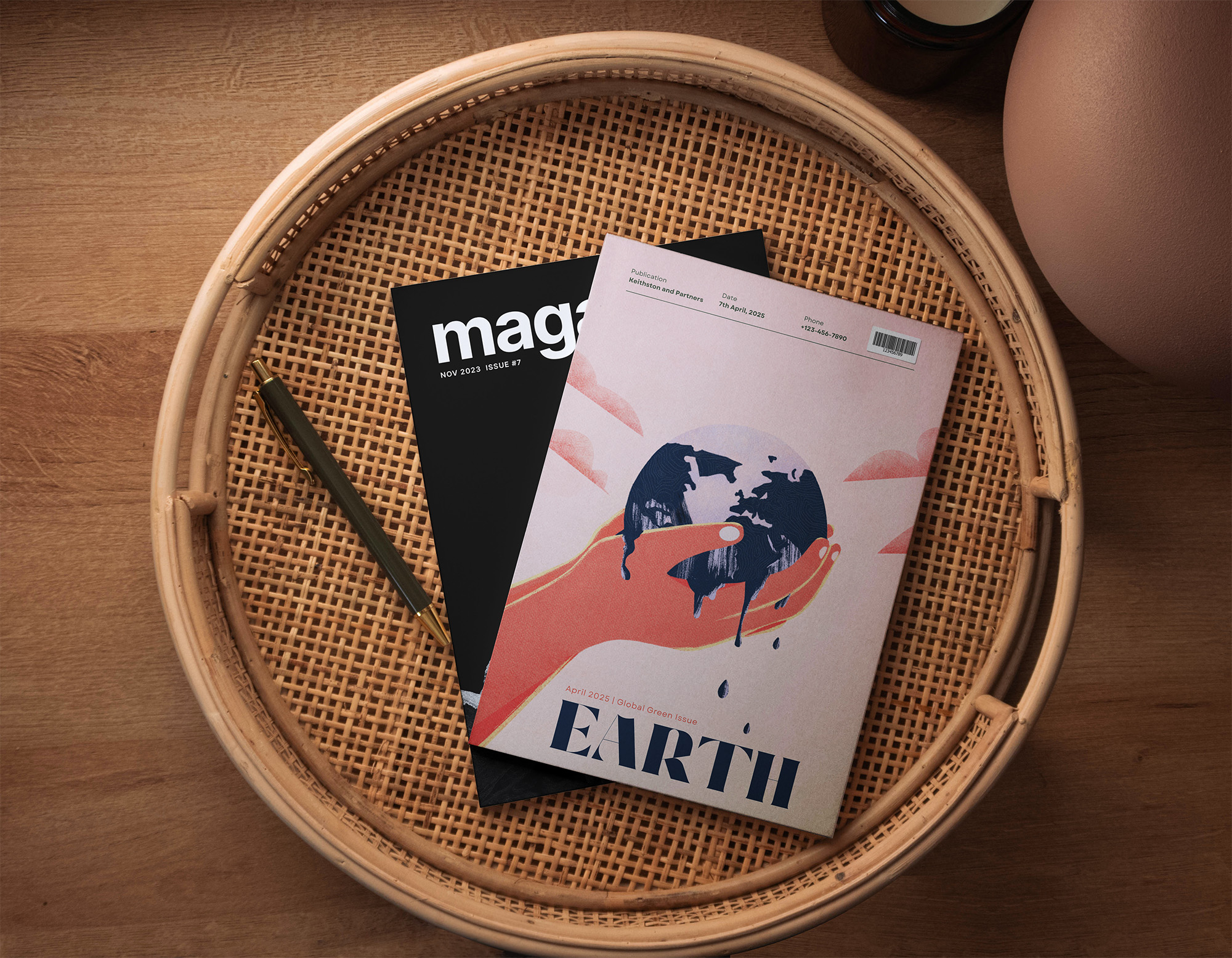 Two printed copies of Earth Magazine laying on a wooden table, showcasing the front cover illustration.